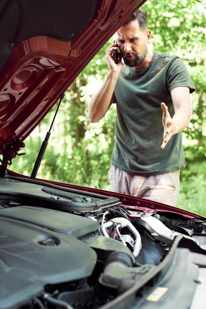 Junger Mann prüft Getriebeschaden bei Schrottauto Ankauf Dorsten
